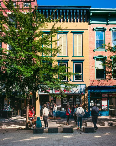 Brick pedestrian mall with historic storefronts and trees